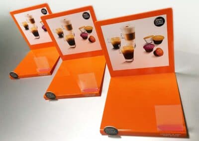 Narancsszínű nyomtatott és hajlított asztali displayek.