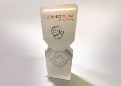 Fehér színű, fémből készült interaktív display. A tetején világító csík, alatta a Connect Media szürke-narancs logója az alatt pedig a from dunnhumby felirat szerepel. Az oldalán egy stilizált nyitott tenyerű kéz rajza is megjelenik, a tenyéren a "connect us" felirattal.
